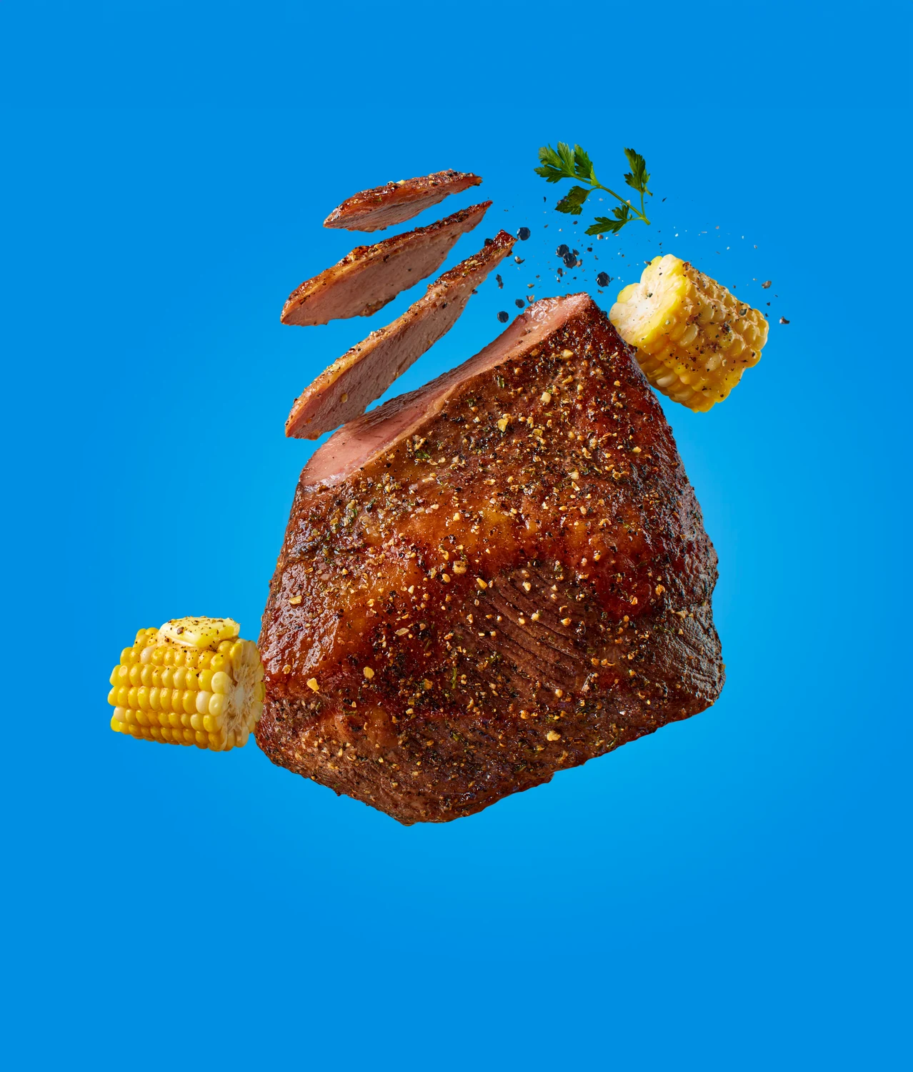 Kroger campaign: a whole beef brisket floating with slices and corn on blue
