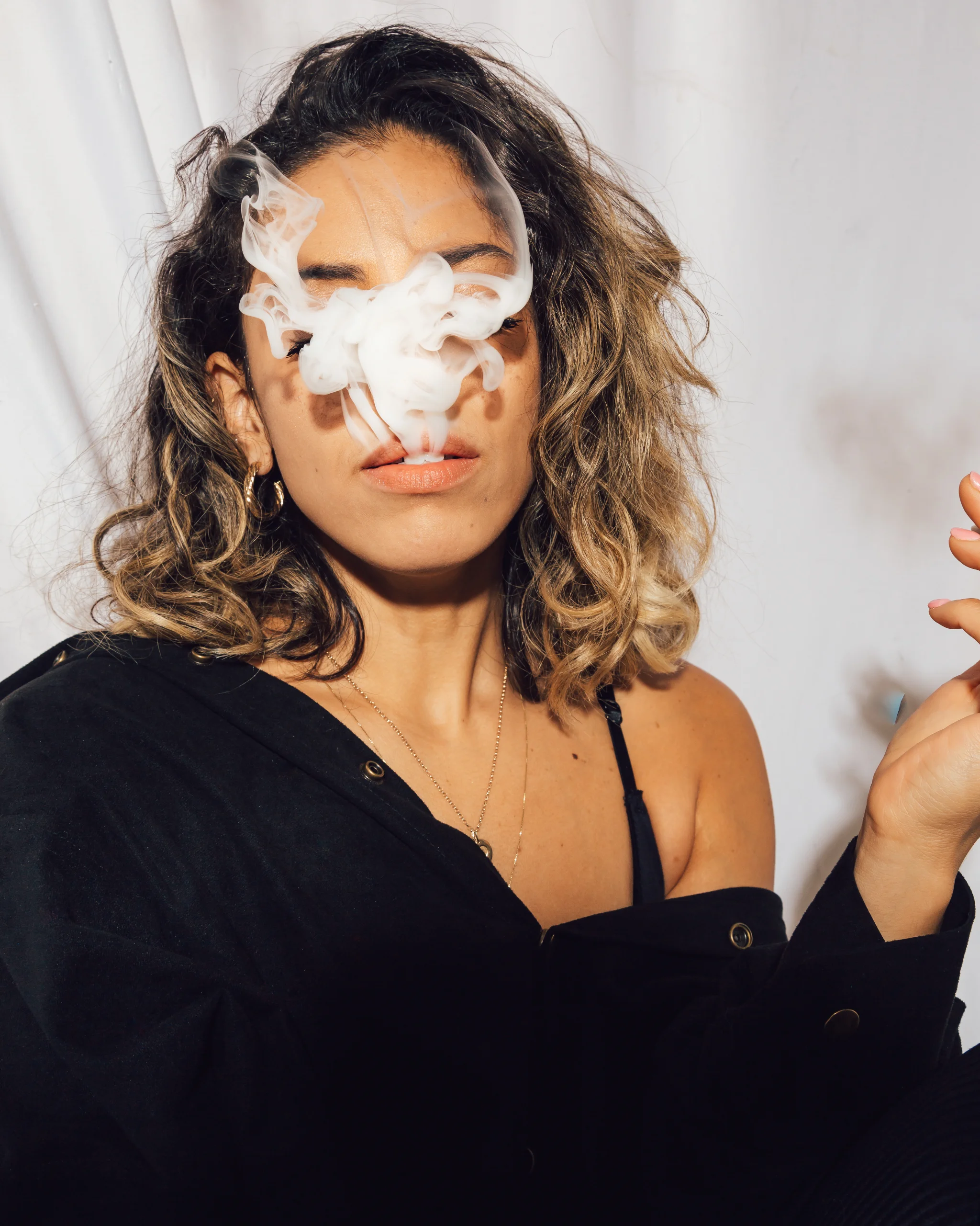 Studio portrait of a woman exhaling smoke