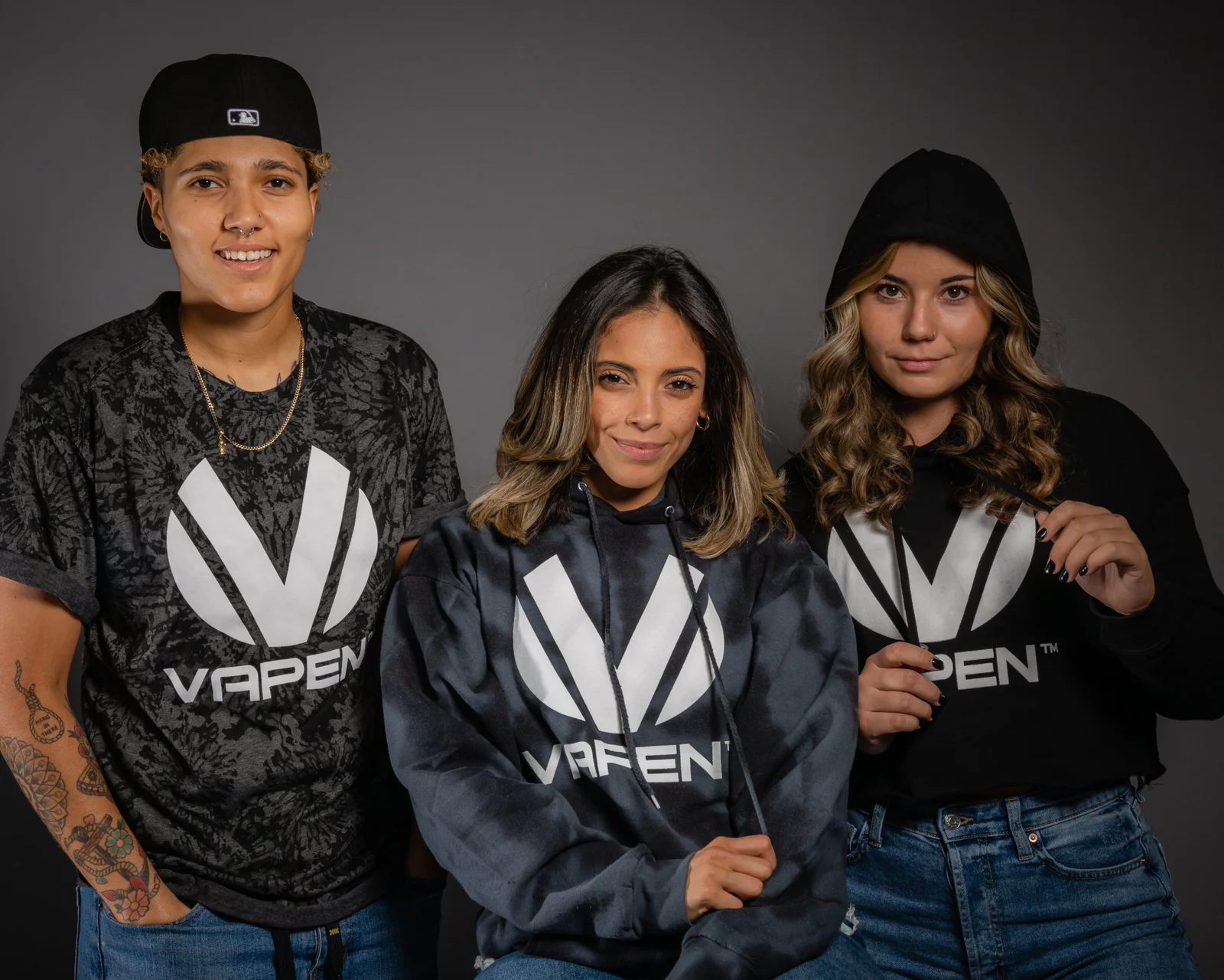 Three people in Vapen hoodies and tees