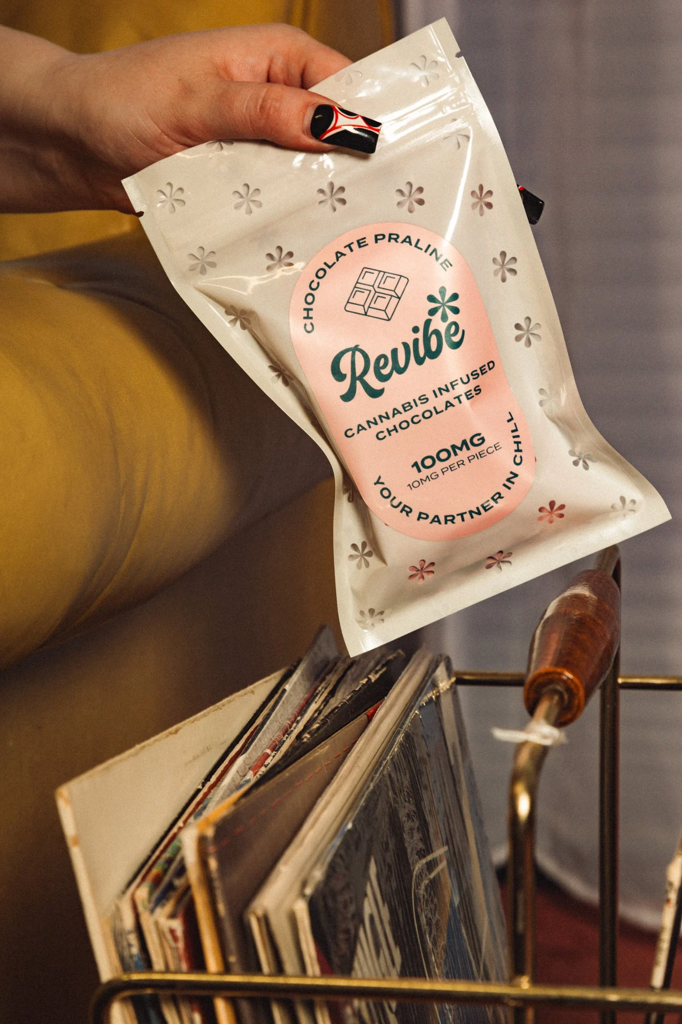 Revibe chocolate praline pouch held over a crate of records